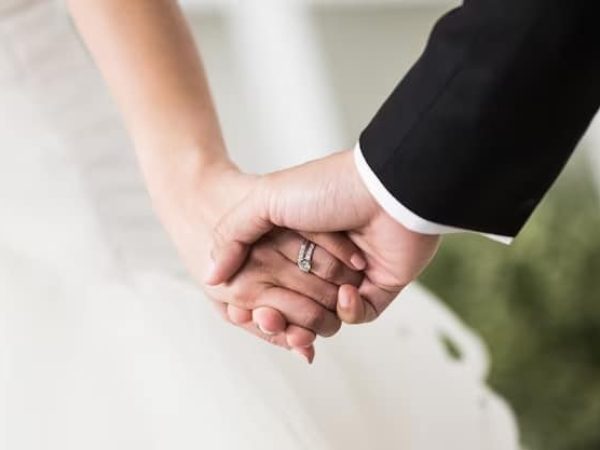 young-married-couple-holding-hands-ceremony-wedding-day_42044-1665